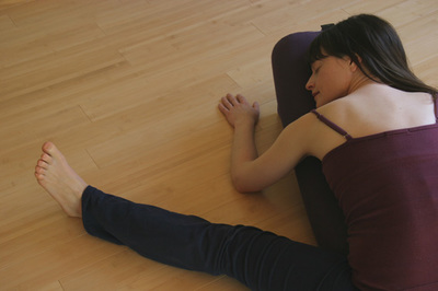 picture of woman resting chest on a yoga bolster