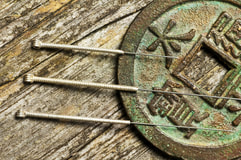 Picture: three acupuncture needles resting on a coin