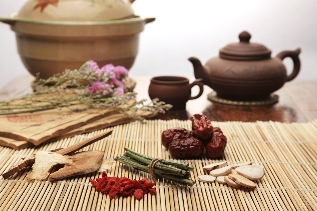 Picture of raw herbs on table with tea pot
